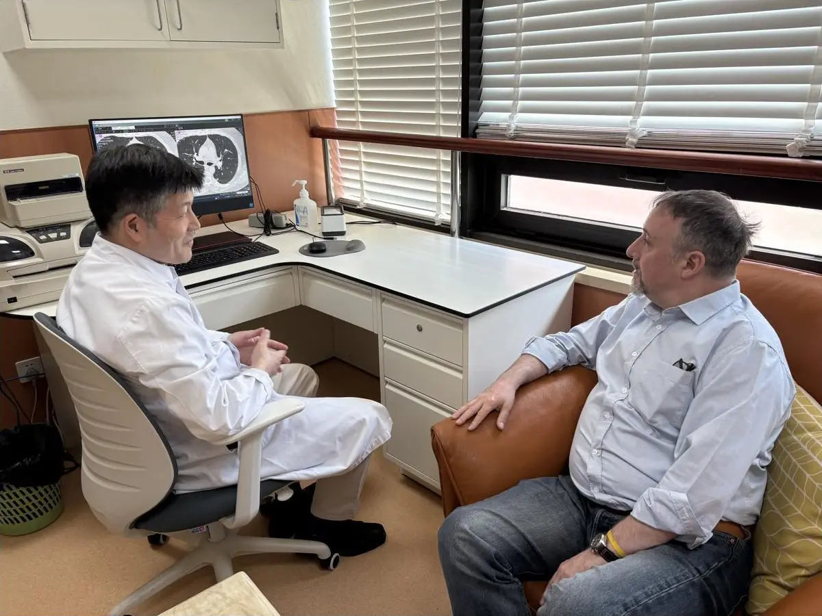 A Chinese specialist reviewing chest imaging with an international patient in Shanghai.