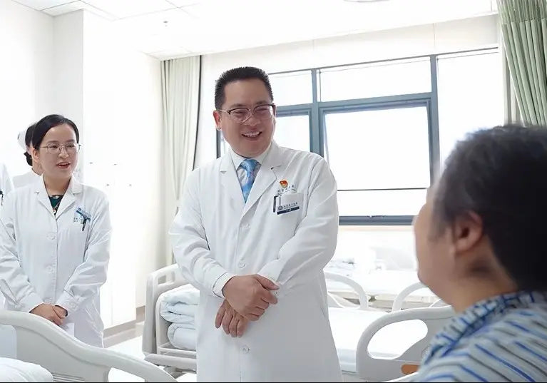 Chinese physicians speaking directly with a patient in a modern hospital.