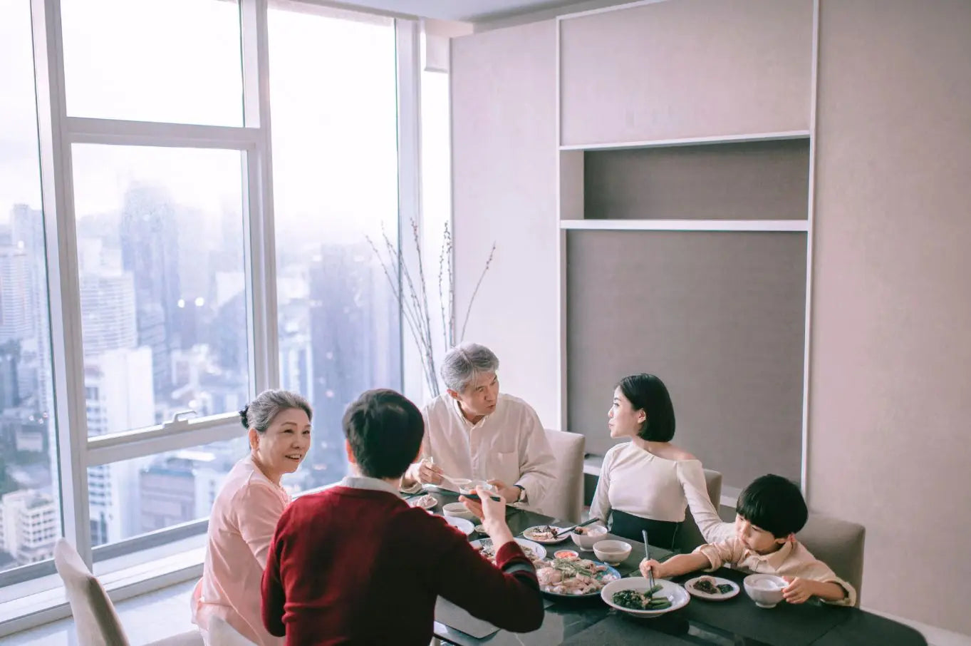 A modern Chinese family sharing a meal together in a city home.
