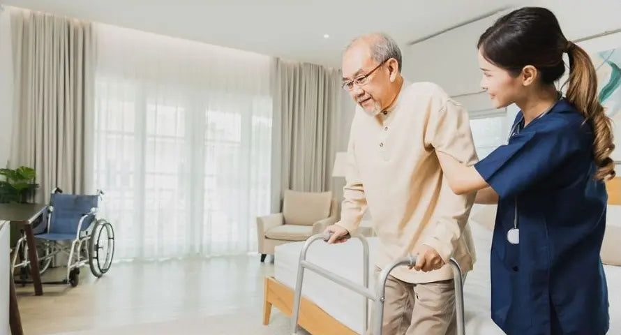 A care professional helping an older man move safely in his own home.